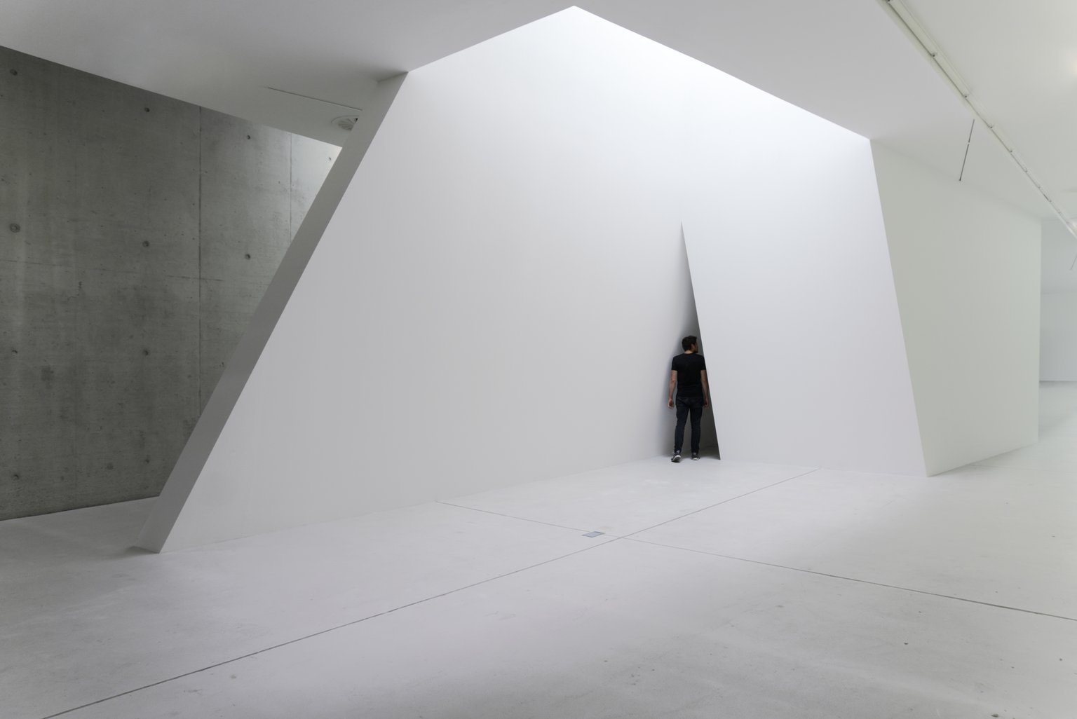 Hatch by Emil Walde, 2022, wood, screws, spackling compound, white wall paint, video projection