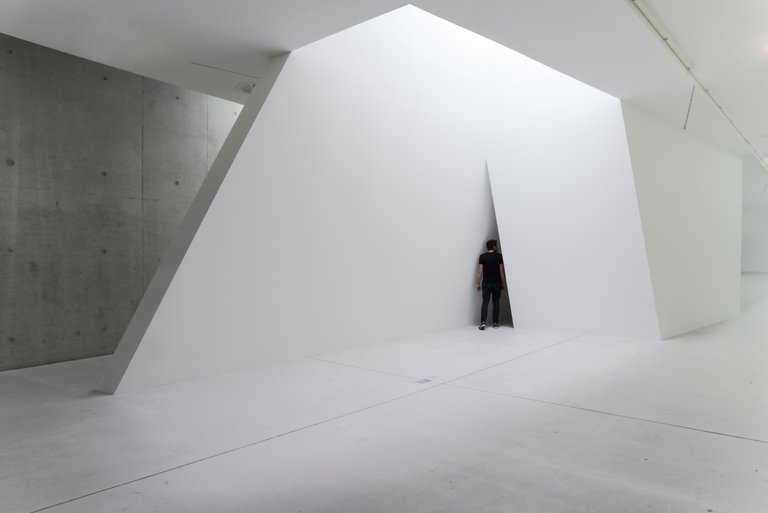 Hatch by Emil Walde, 2022, wood, screws, spackling compound, white wall paint, video projection