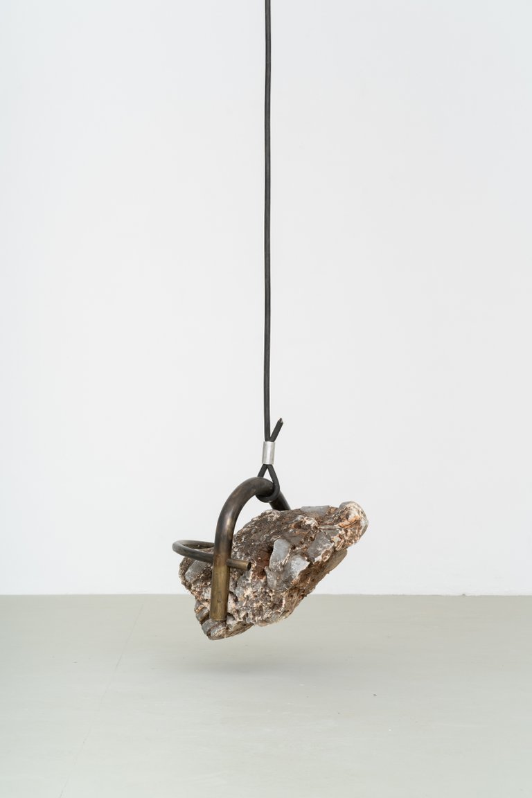 Abschied von der Erde by Nino Maaskola, 2025, stone, brass, cable, aluminum